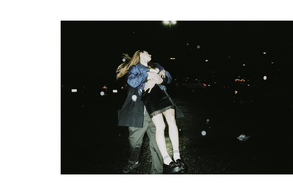 a couple playing in a rainy parking lot