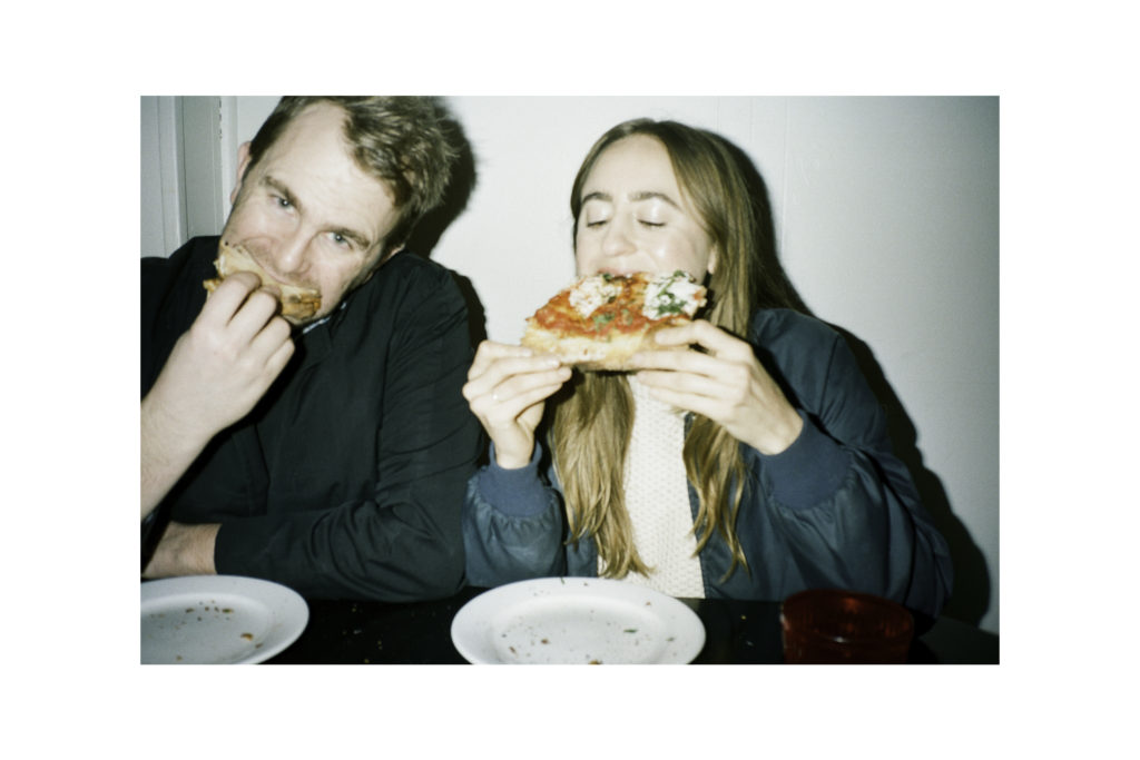 a couple eating slices of pizza