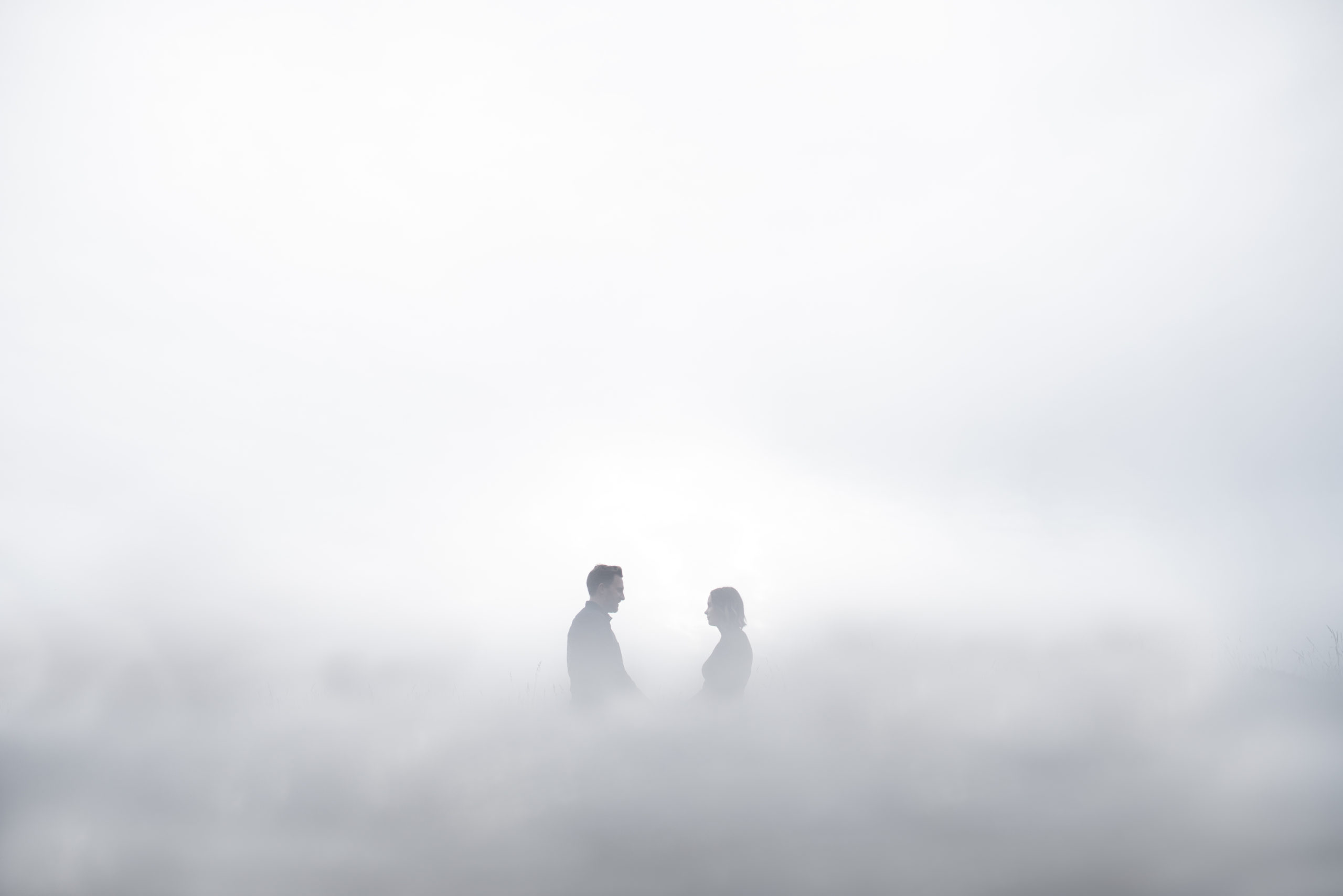 the silhouette of a couple in fog