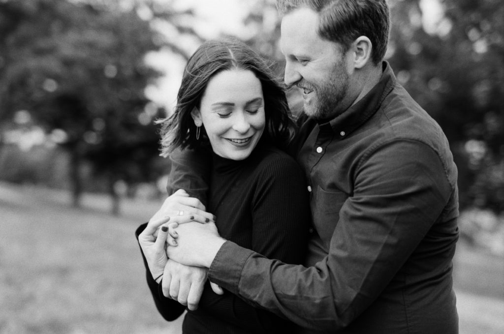 a couple in black and white laughing while hugging